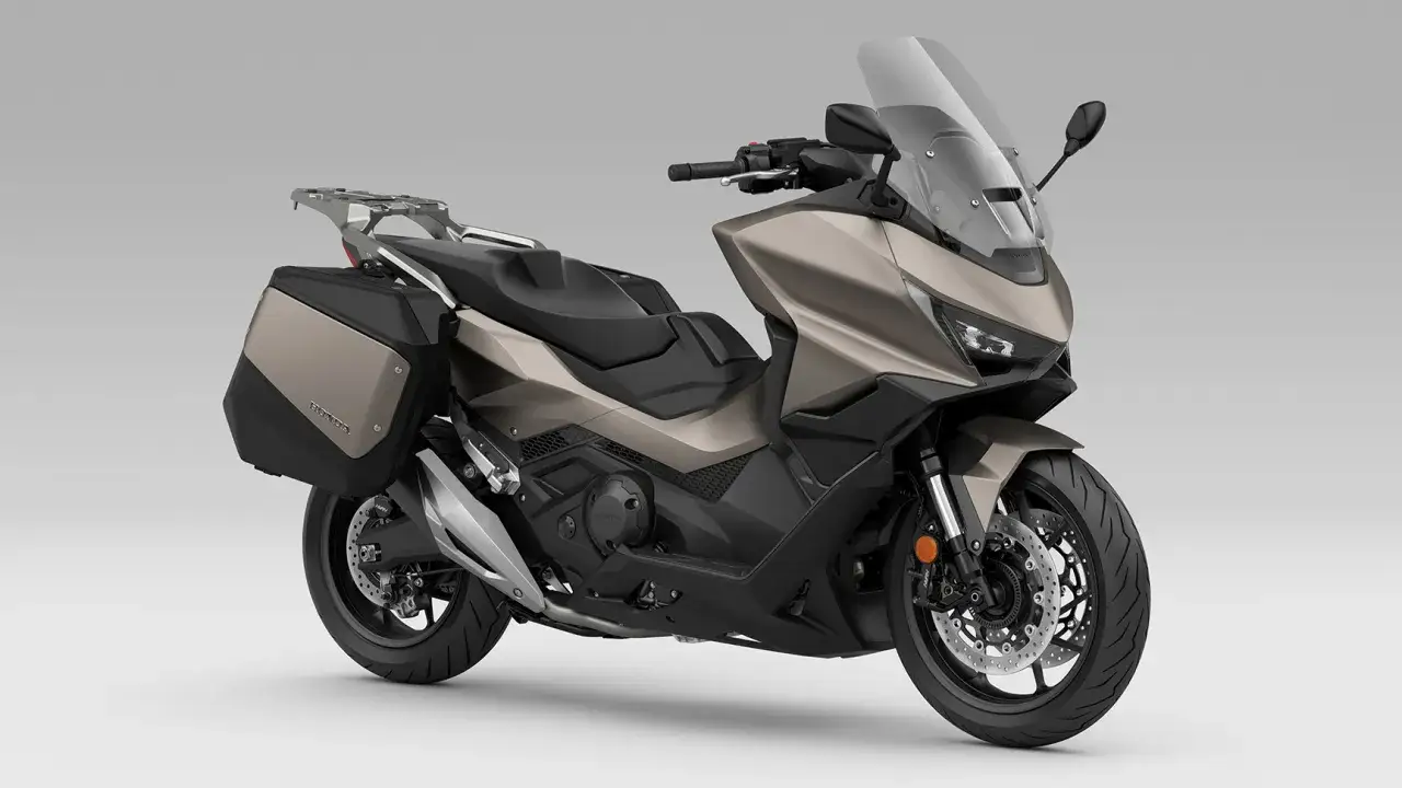Honda Forza 750 en color bronce con maletas laterales, lista para la aventura. Consulta su ficha técnica.