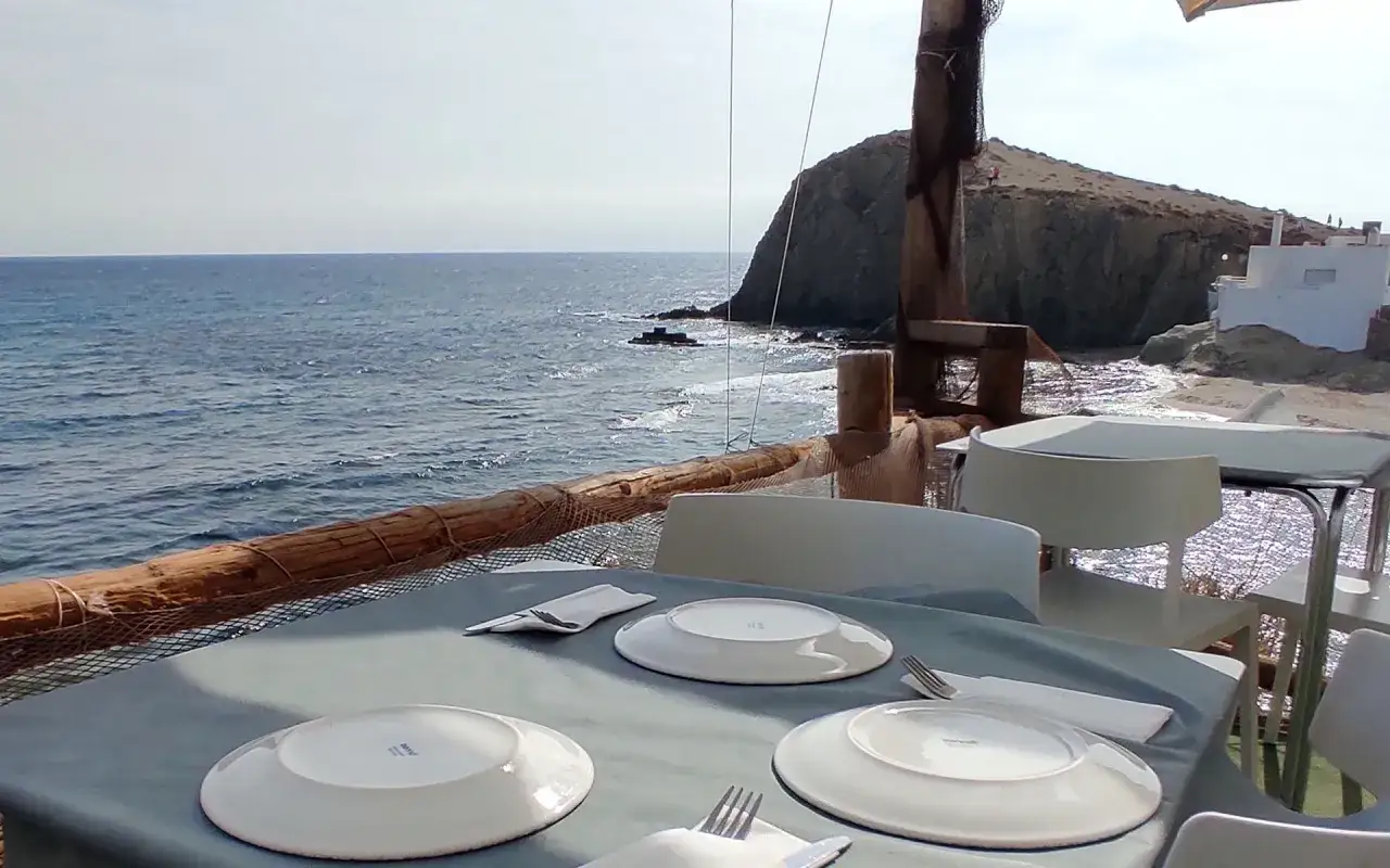 Mesas puestas en restaurantes el ejido con vistas al mar y acantilados.