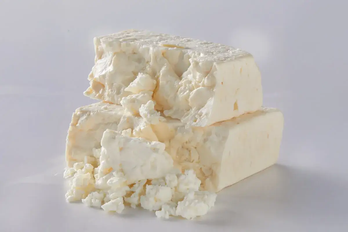 Gros morceaux de fromage blanc, émiettés, posés l'un sur l'autre. Une texture qui rappelle pourquoi le lait est blanc.