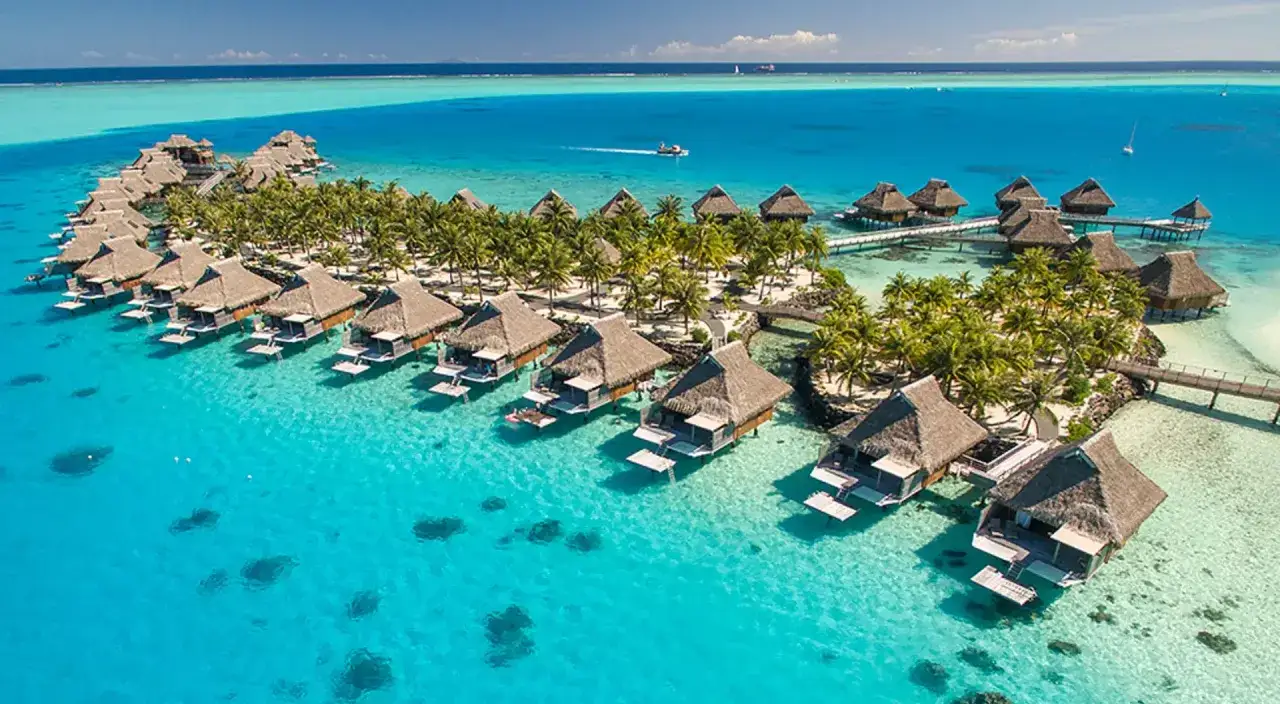 Bora-Bora loty: luksusowe bungalowy na wodzie w turkusowej lagunie, otoczone palmami. Rajskie wakacje.