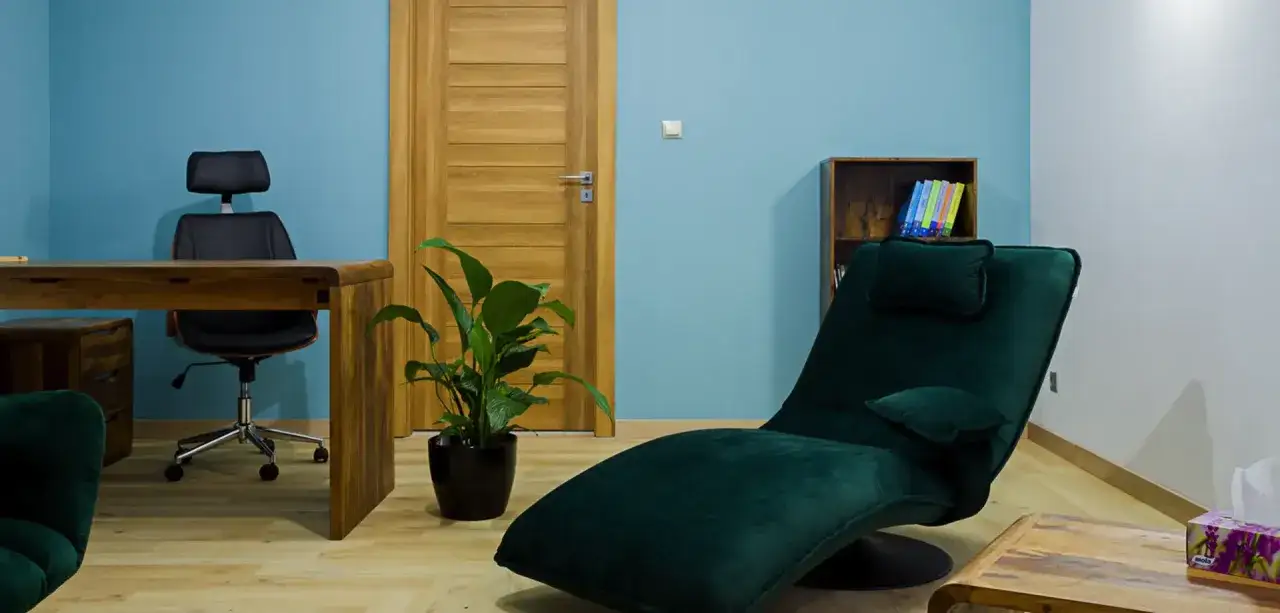Gabinet terapeutyczny z fotelem do leżenia, biurkiem i rośliną. Miejsce, gdzie można opowiedzieć o swoich problemach, nawet tych związanych z mitomanią.