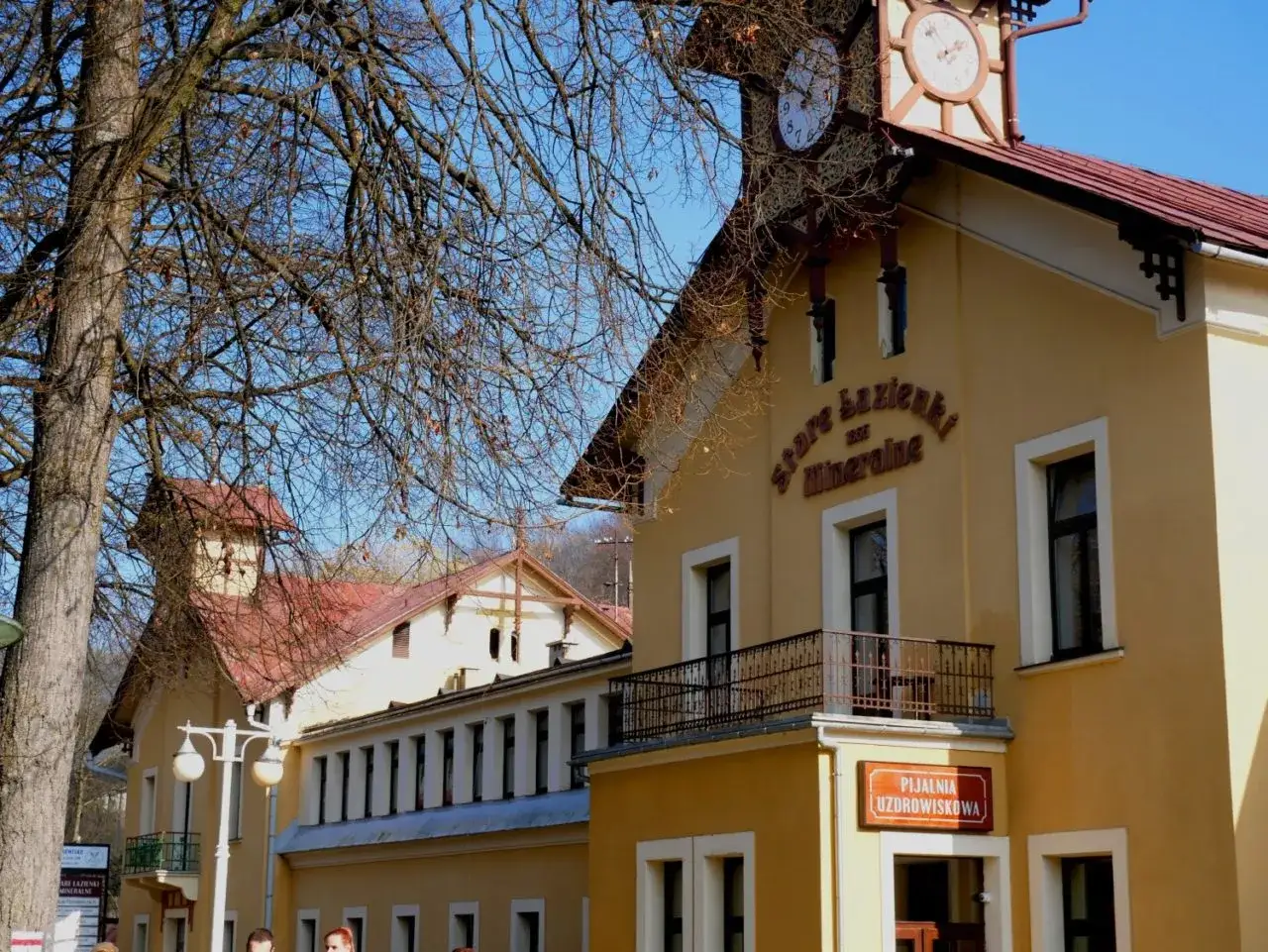 Stare łazienki Krynica Zdrój, zabytkowy budynek z zegarem na wieży, zaprasza do Pijalni Uzdrowiskowej.