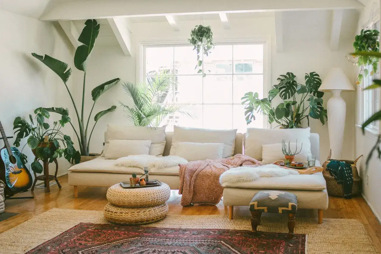 Boho living room with plants, guitar, and cozy textiles. This space showcases rental friendly upgrades like plants and decor that add personality without permanent changes.