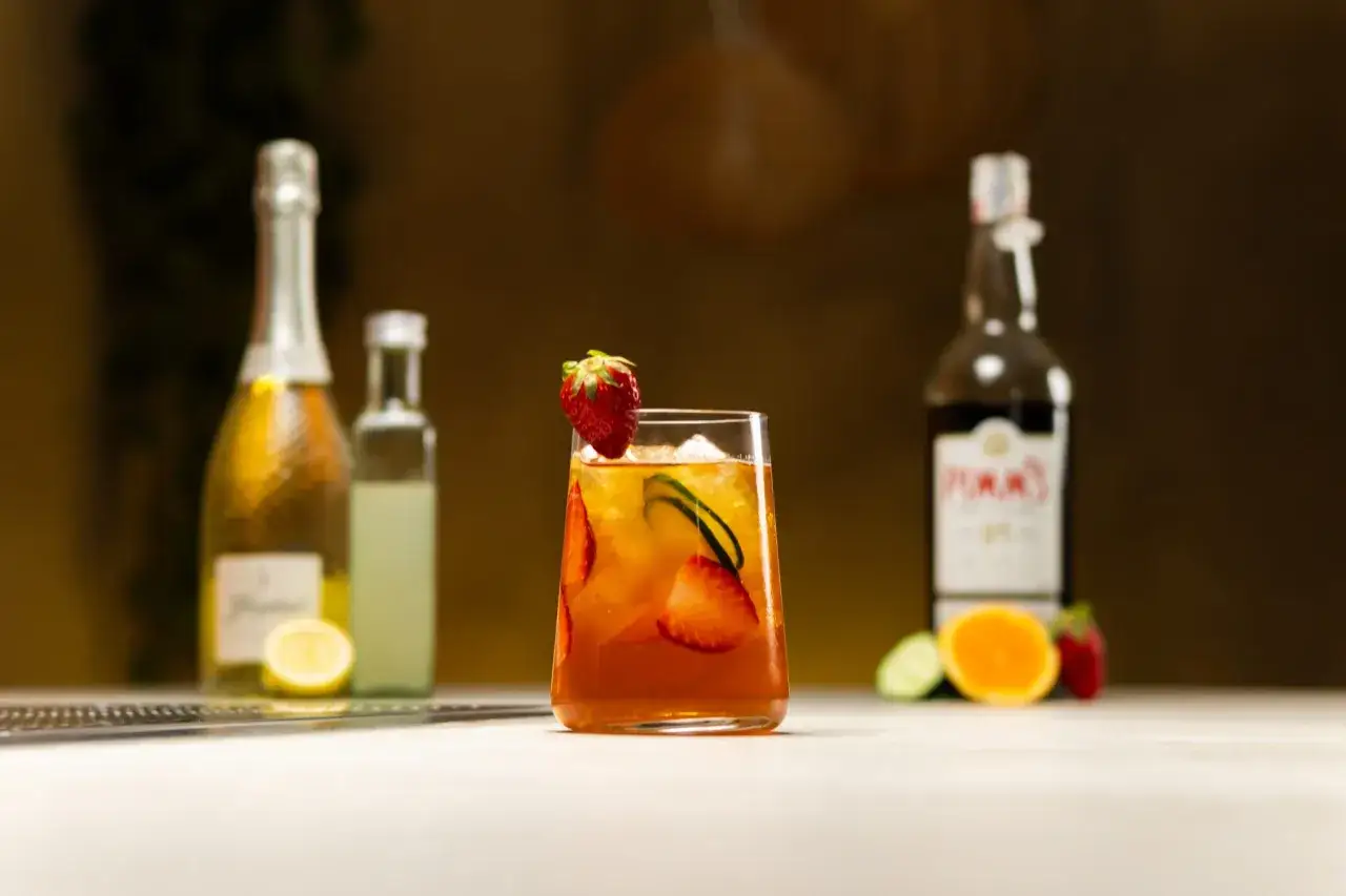Orzeźwiający drink z Pimm's No. 1, truskawkami i ogórkiem, gotowy do porównania z Aperol Spritz.