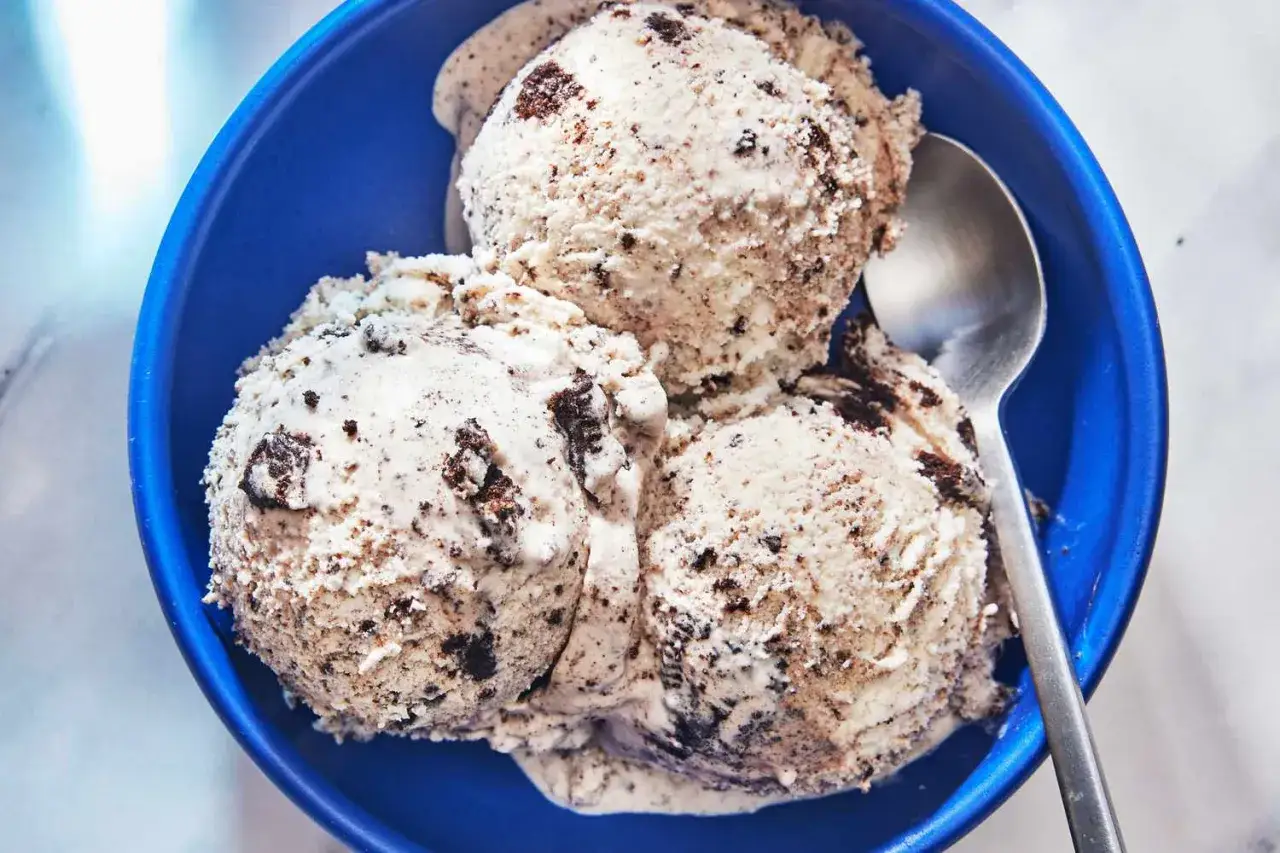 Drei Kugeln cremiges Cookies Eis in einer blauen Sch&uuml;ssel, bereit zum Genie&szlig;en.