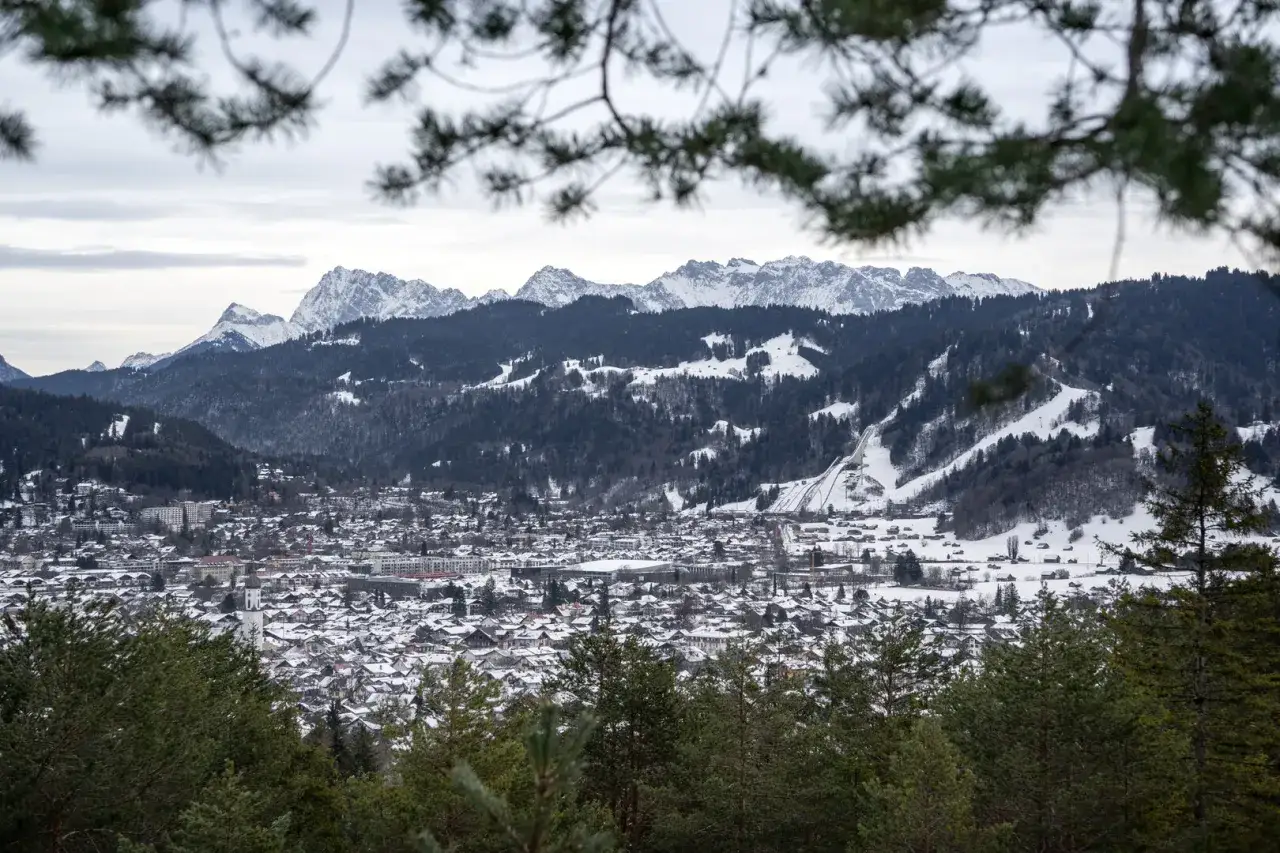 Winterpanorama mit schneebedecktem Dorf und Bergkulisse. Der Kramerplateauweg rundweg bietet diese Aussicht.