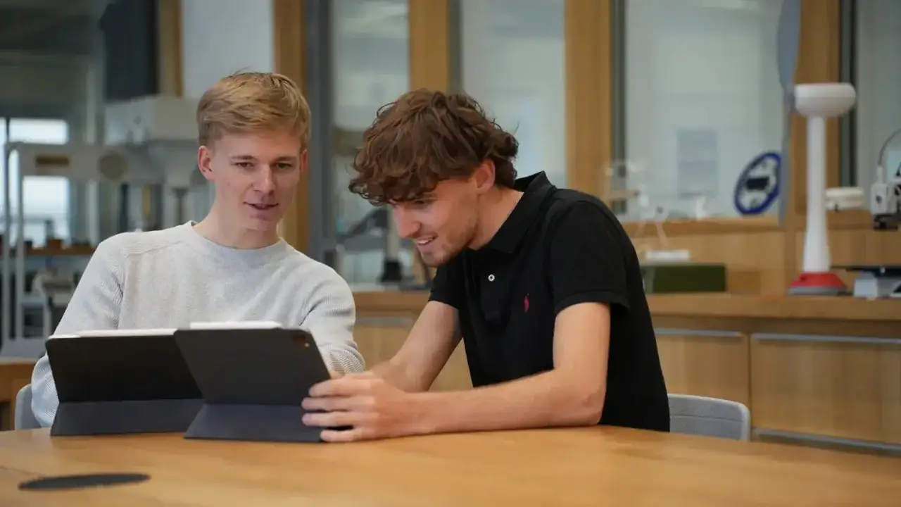 Zwei Studenten arbeiten an Tablets. Sie sind Teil eines wirtschaftsinformatik studium nrw.