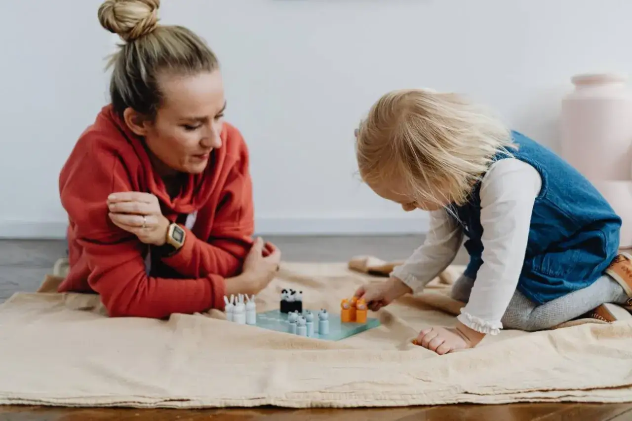 Mama i dziecko grają w planszówkę. Czasem taki wspólny moment to dowód, że idealny rodzic nie istnieje, a liczy się bliskość.
