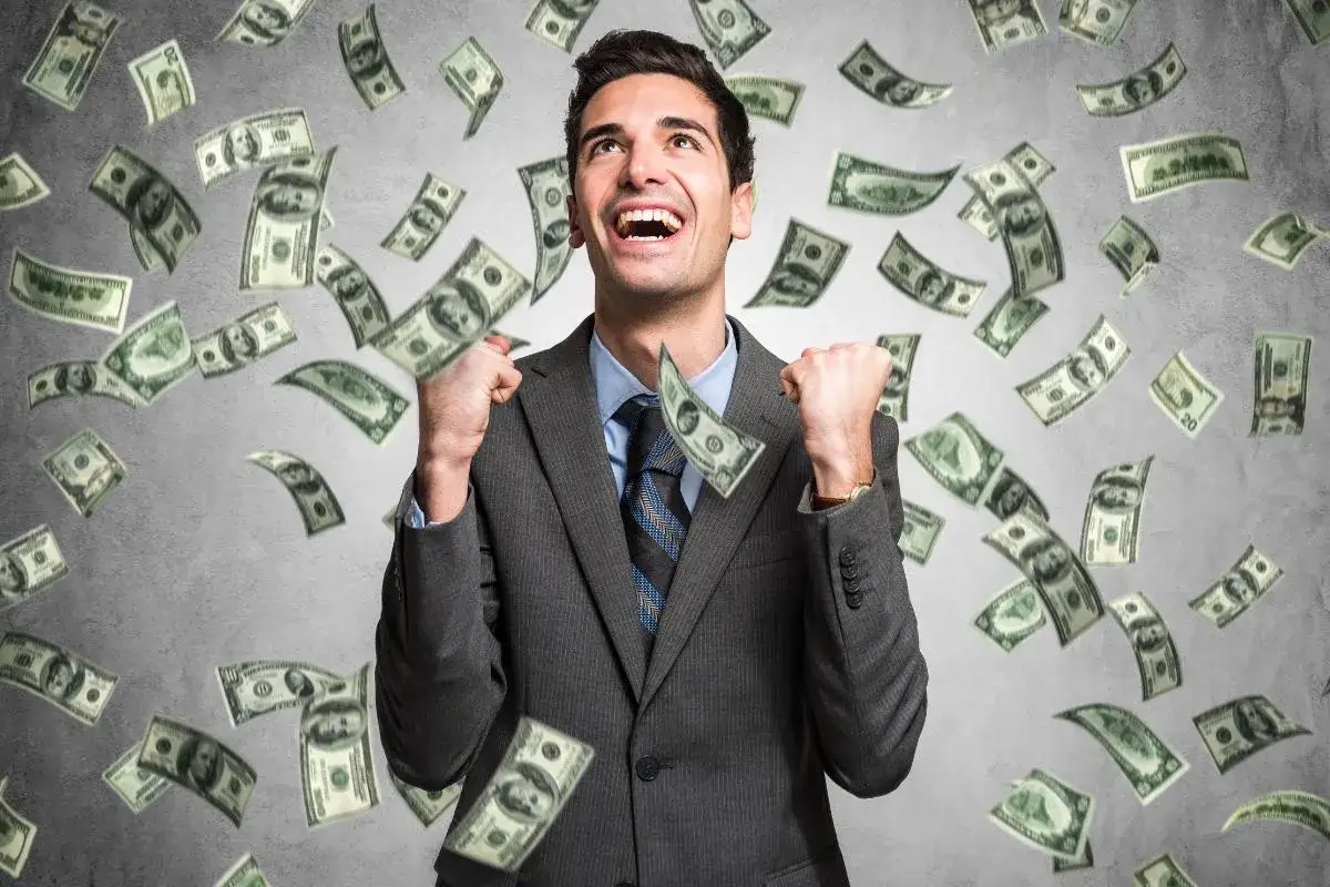 Hombre con traje celebra mientras llueven billetes, como si so&ntilde;ara que le toca la loter&iacute;a. &iexcl;La felicidad de la fortuna!