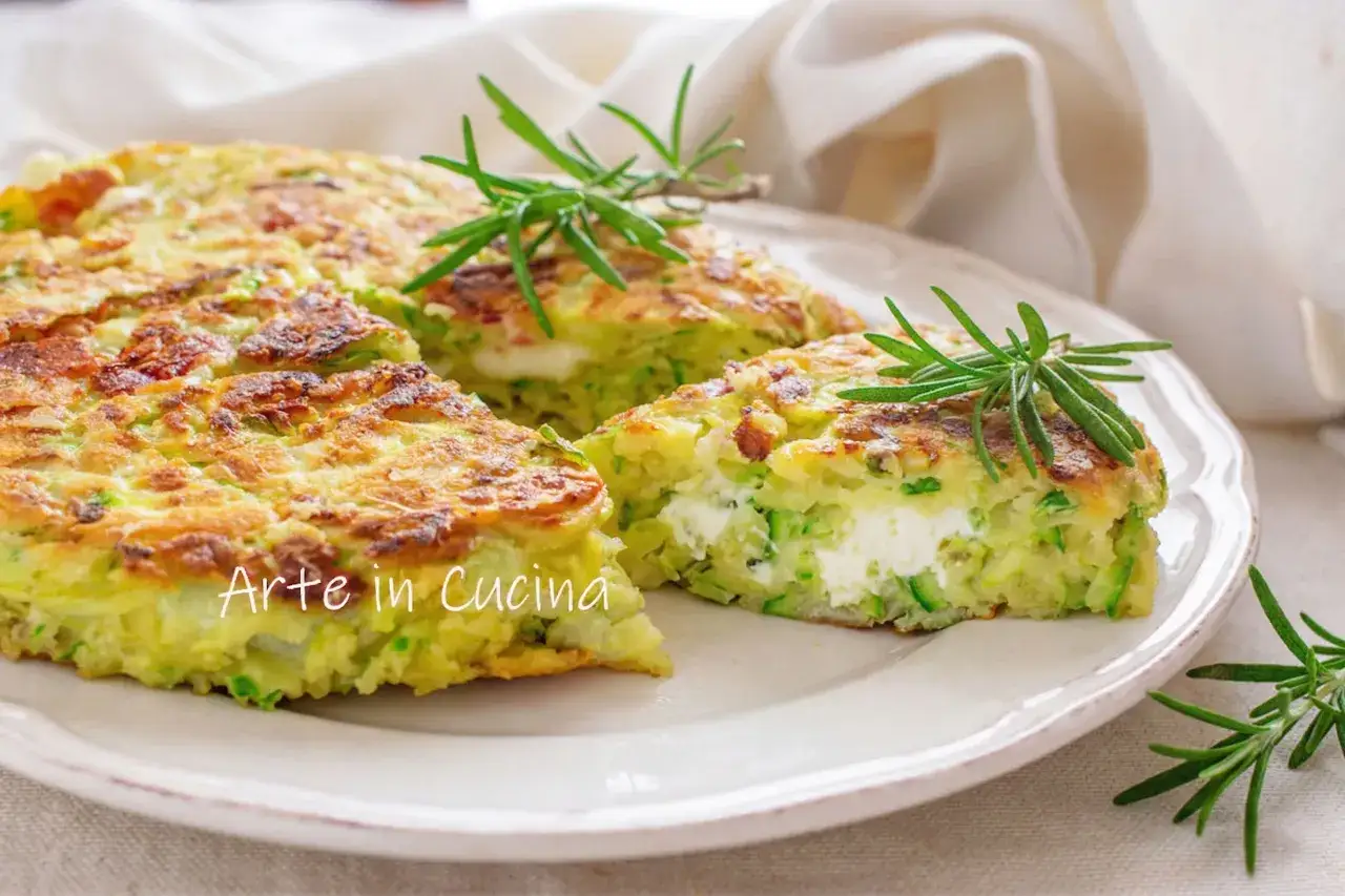 Une délicieuse quiche ricotta aux courgettes, garnie de romarin frais, sur une assiette blanche.