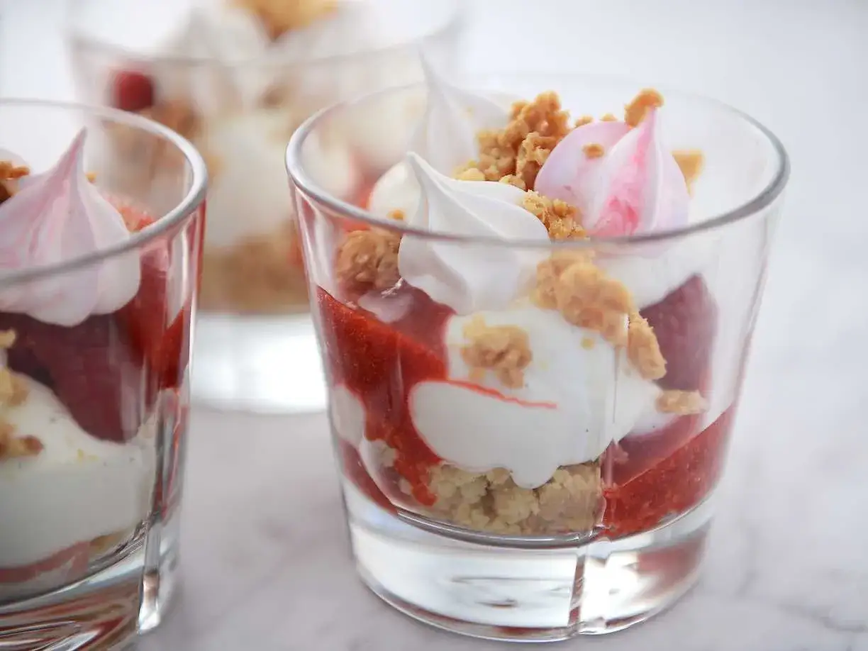 Ljuvlig Eton Mess i glas: lager av jordgubbar, grädde, smulad maräng och krispigt strössel. En perfekt sommardessert.