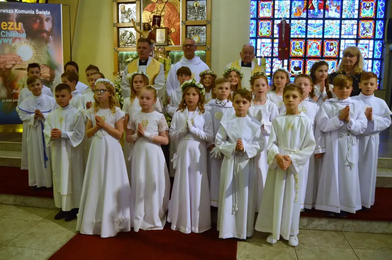 Dzieci w białych strojach komunijnych, przygotowujące się do przyjęcia sakramentu. Czy po spowiedzi trzeba przyjąć komunię? To pytanie zadają sobie młodzi wierni.