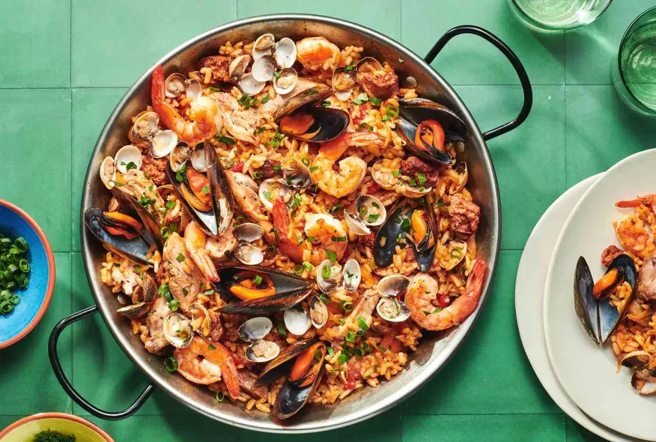 Paella généreuse avec poulet, crevettes, moules et palourdes. Un délice qui invite à se demander quel vin avec paella poulet fruits mer.