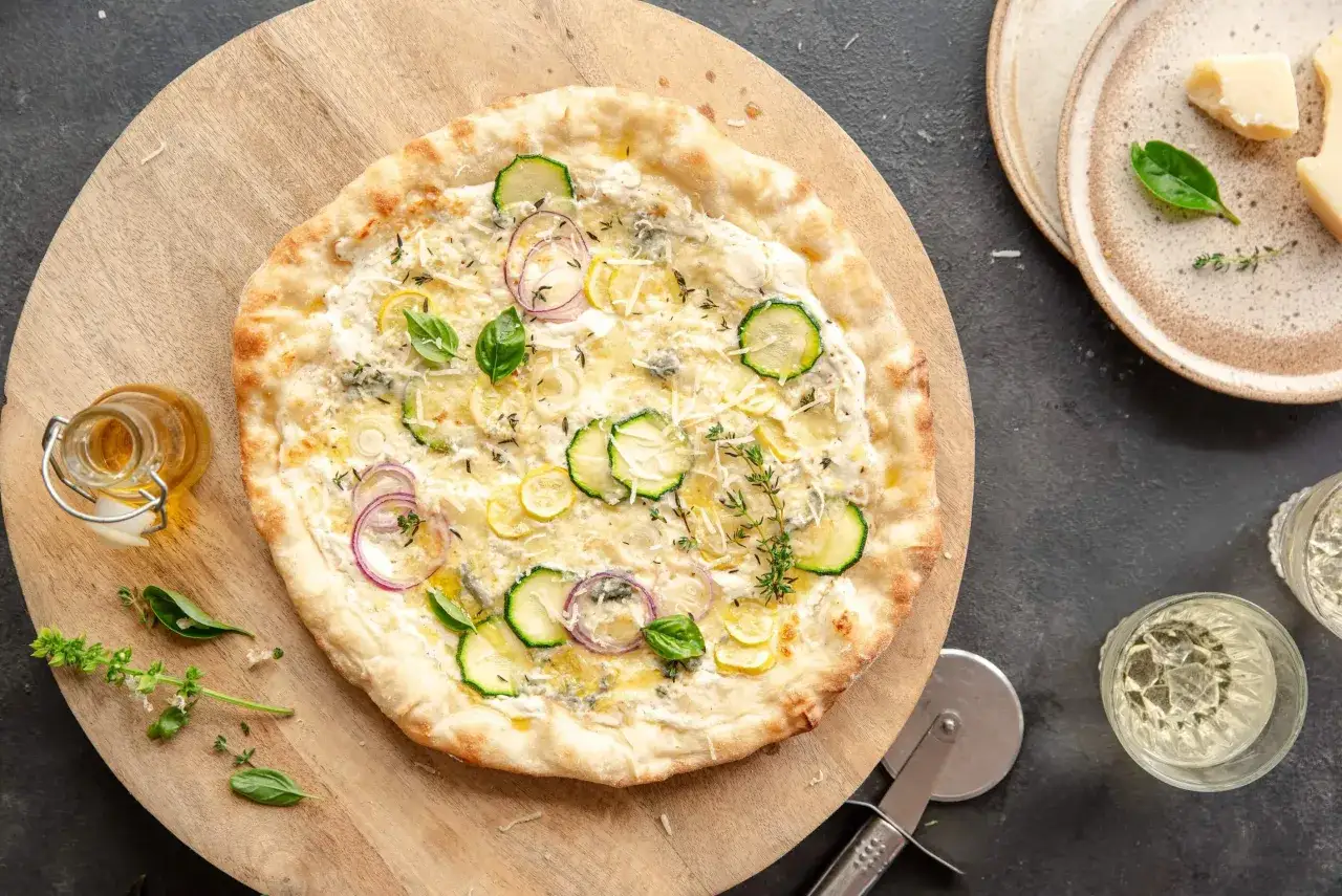 Pizza bez sosu pomidorowego z cukinią, cebulą, cytryną i ziołami. Idealna na lekki posiłek.
