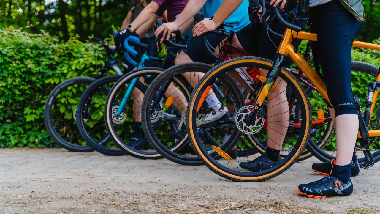 Grupa rowerzystów na szutrowej drodze, gotowa na przygodę. Czy to gravel, czy cross – liczy się jazda!