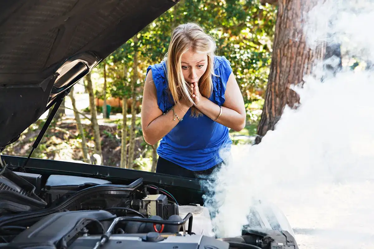 Mujer sorprendida mira humo saliendo del motor de su coche. &iexcl;No se puede circular con el turbo roto!