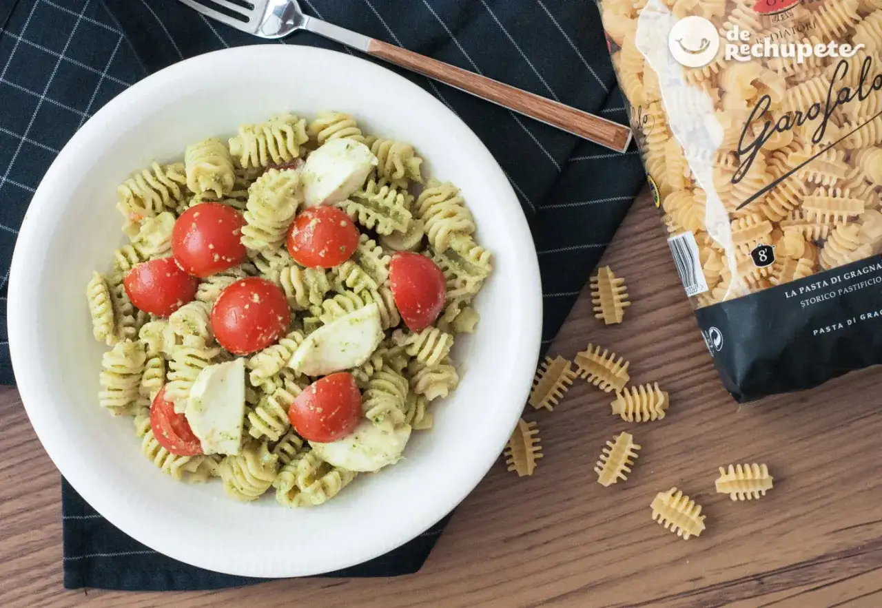 Deliciosa ensalada de pasta al pesto con tomates cherry y trozos de mozzarella fresca. Un plato ligero y lleno de sabor.