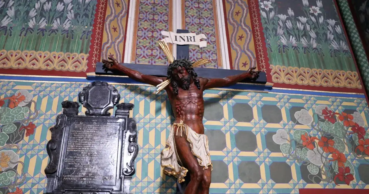 Drewniany Chrystus na krzyżu, z tabliczką INRI, w kościele. Symbol Wielkiego Piątku modlitwy.
