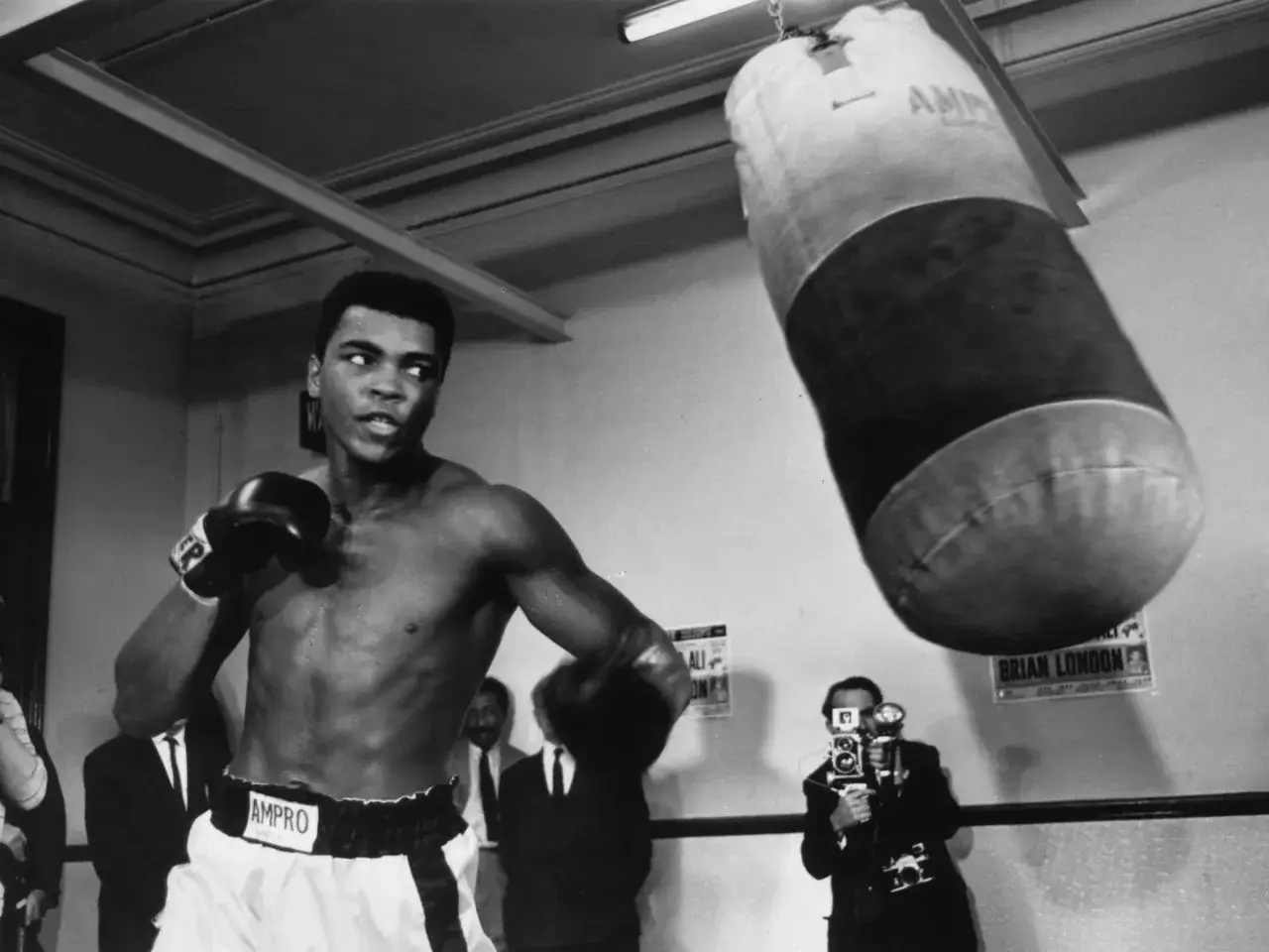 Muhammed Ali tr&auml;nar med en sands&auml;ck, redo f&ouml;r n&auml;sta match. En kameraman filmar hans f&ouml;rberedelser.