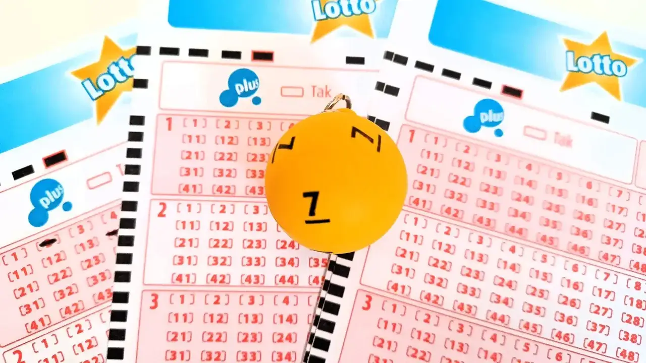 Żółta kulka z numerem 7 na tle kuponów Lotto i Lotto Plus. Czy to szczęśliwa siódemka, która przyniesie wygrane?