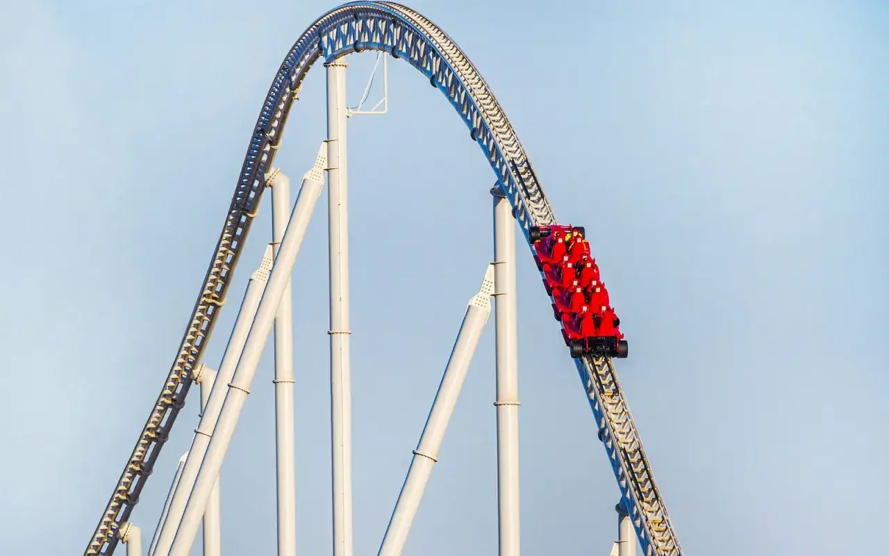 Czerwony wagonik kolejki górskiej zjeżdża po torach w Ferrari World w Dubaju.