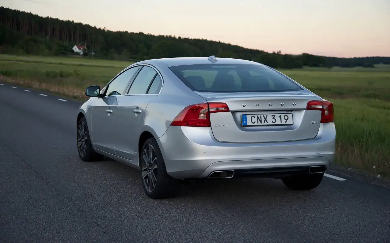 Srebrne Volvo S60 D4 na drodze, z tyłu widoczne światła i tablica rejestracyjna. Idealne wymiary dla rodziny.