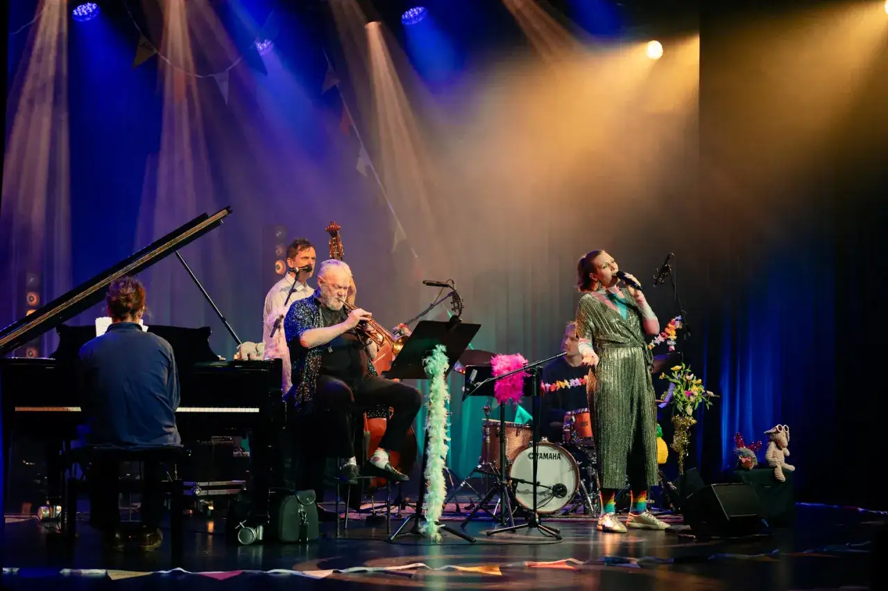 En jazzkvartett spelar p&aring; scenen under Stockholm Jazz Festival. En s&aring;ngerska i glittrig kl&auml;nning, en trumpetare, en pianist och en trummis.