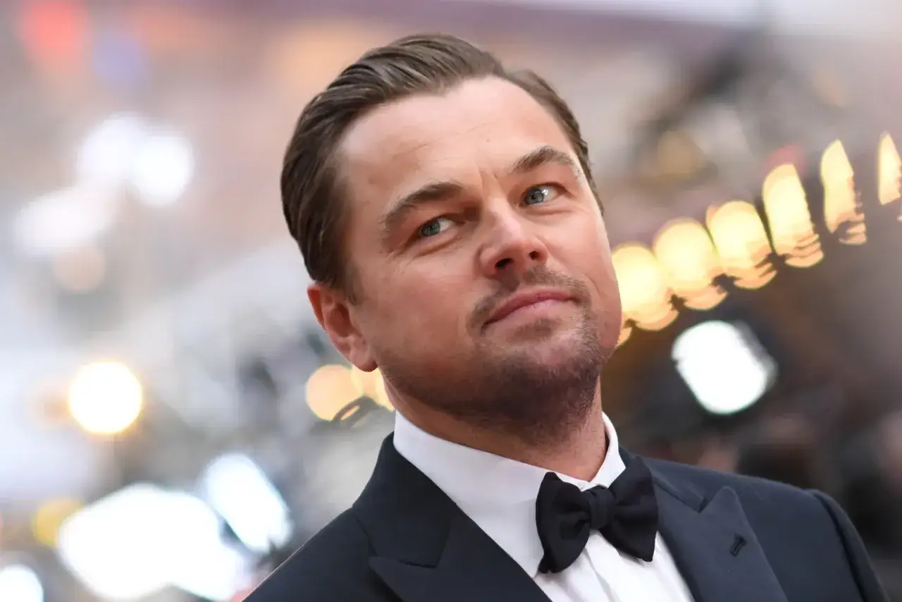 Leonardo DiCaprio w garniturze z muszką, zastanawia się, ile zarabia Leonardo DiCaprio.