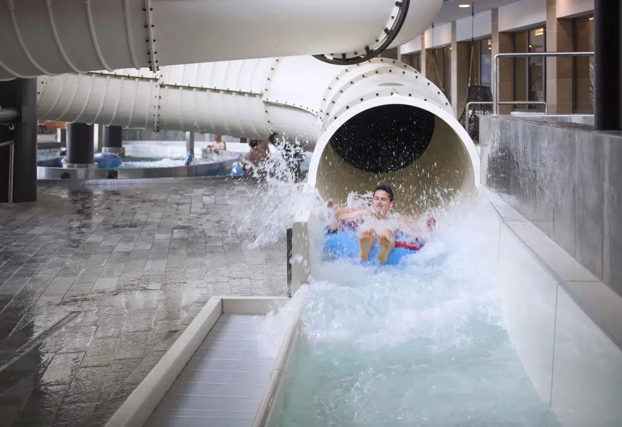 Un ragazzo si diverte su un gommone nella piscina acquatica, un momento di gioia durante il **das gerstl family retreat**.