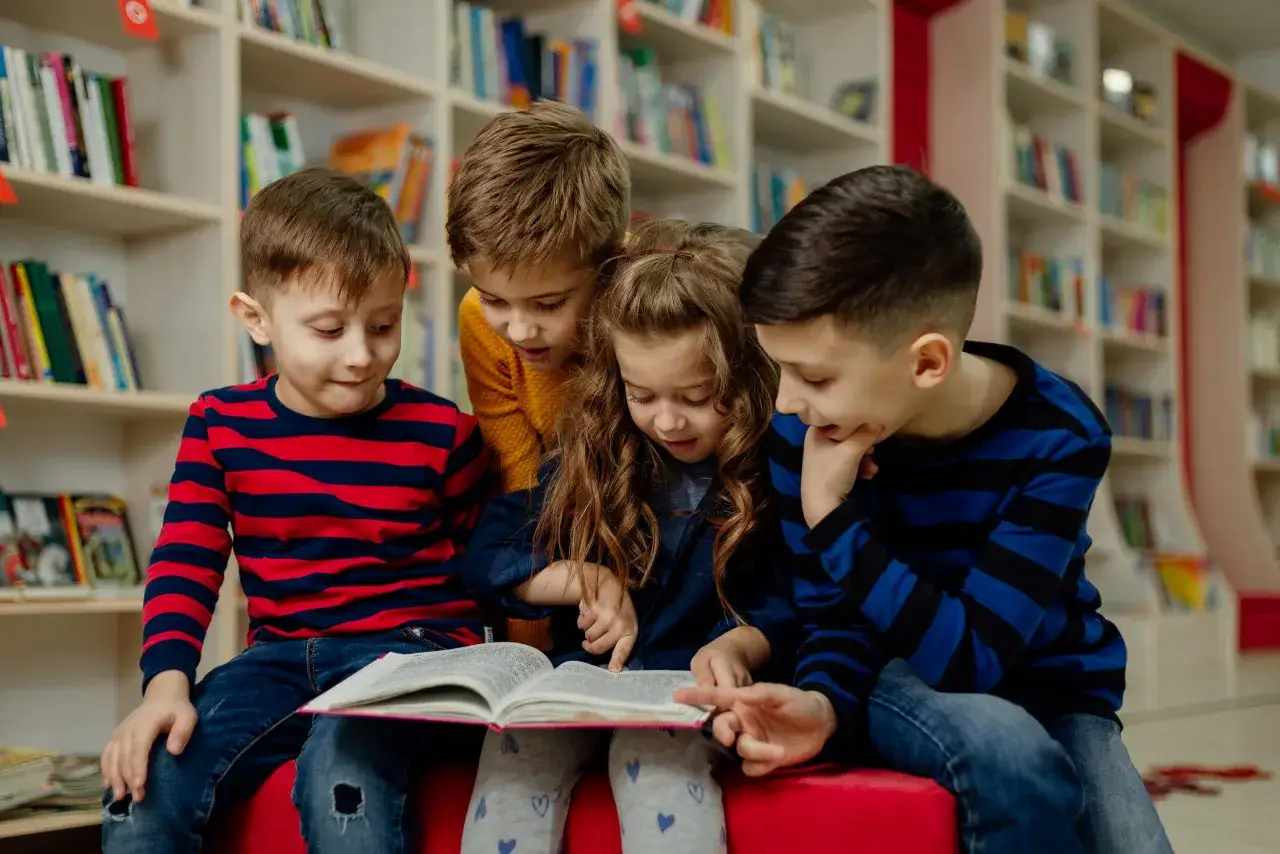 Ni&ntilde;os concentrados en un libro, aprendiendo sobre velocidad lectora primaria.