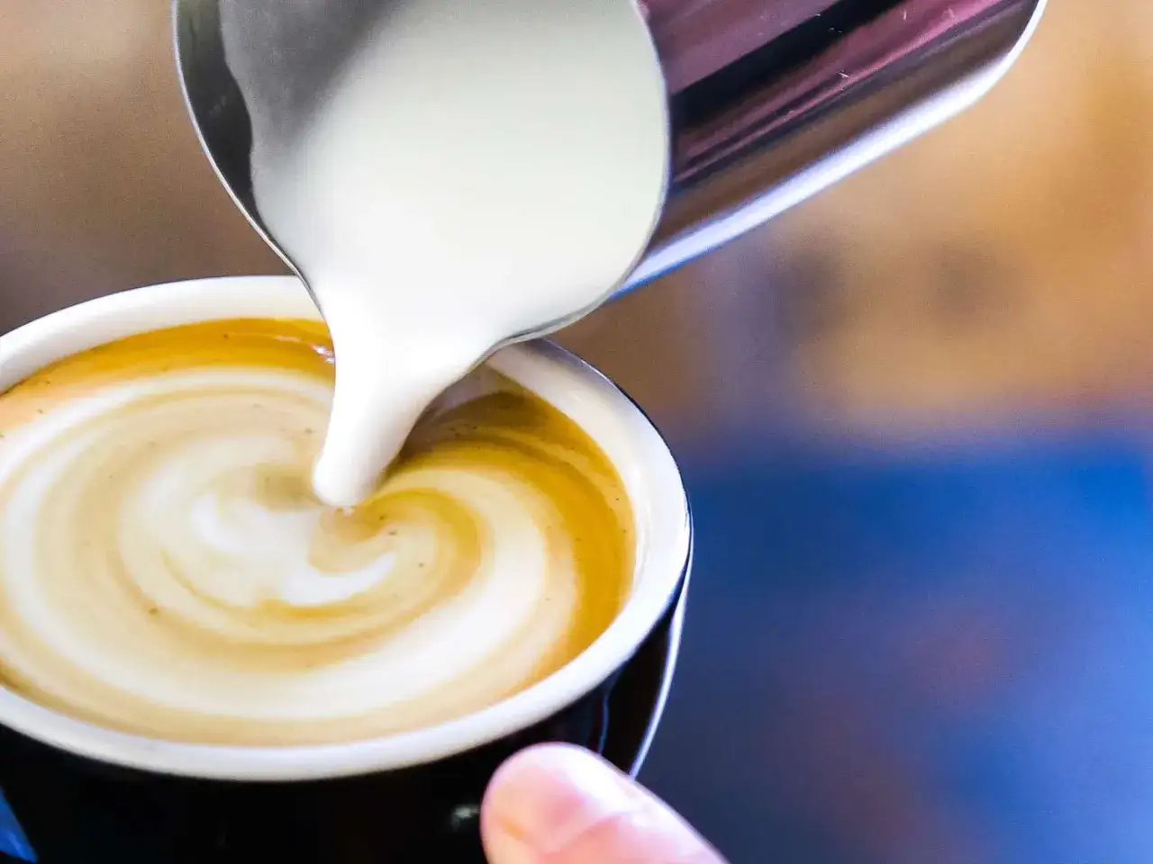 När mjölken virvlar ner i kaffet skapas ett vackert mönster. En perfekt kopp kaffe med vitt.