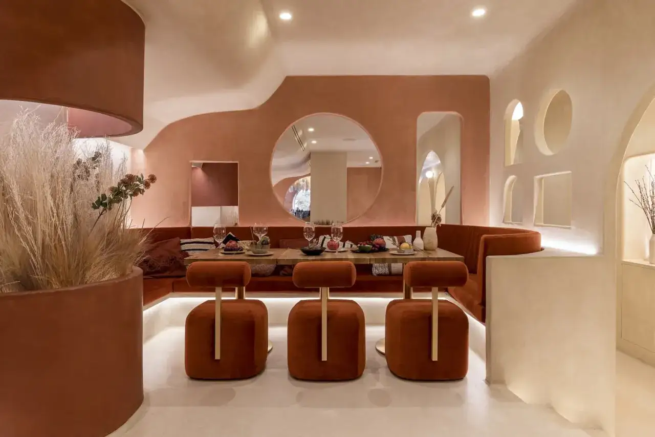 Un interno accogliente dove il color mattone domina, creando un'atmosfera calda e invitante. Sedute imbottite, un tavolo apparecchiato e dettagli decorativi che mostrano come abbinare il color mattone con stile.