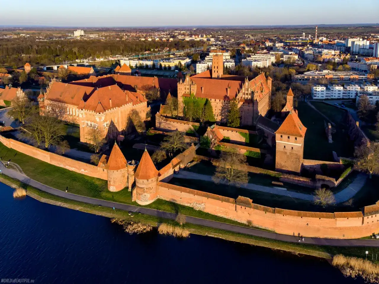 Imponujący zamek w Malborku, jeden z najpiękniejszych zamków w Polsce do zwiedzania, otoczony murami obronnymi i wodą.
