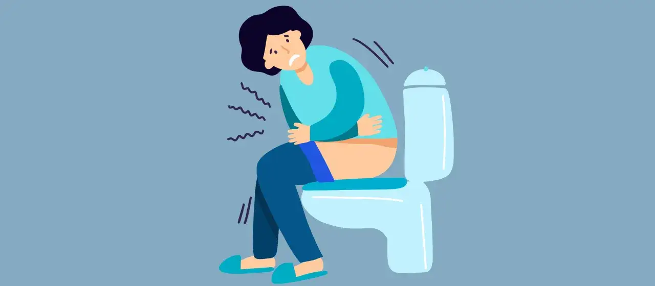 Persona con dolori addominali seduta sul water, preoccupata per le possibili cause della steatorrea.