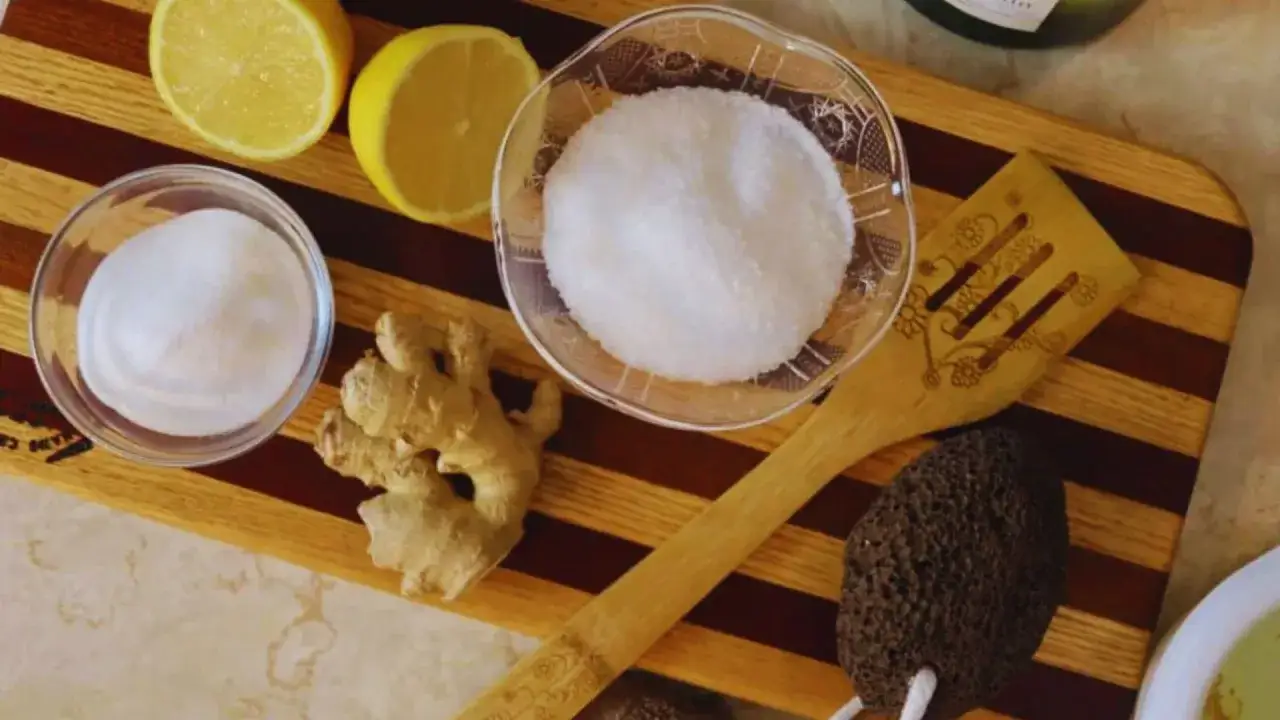 Ingredients for a homemade foot soak to remove dead skin: lemons, ginger, sugar, and a pumice stone.