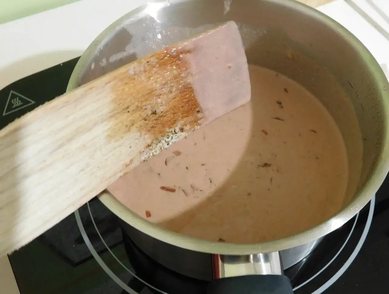 Une spatule en bois remue une sauce onctueuse dans une casserole. C'est le d&eacute;but d'une sauce porto facile et d&eacute;licieuse.