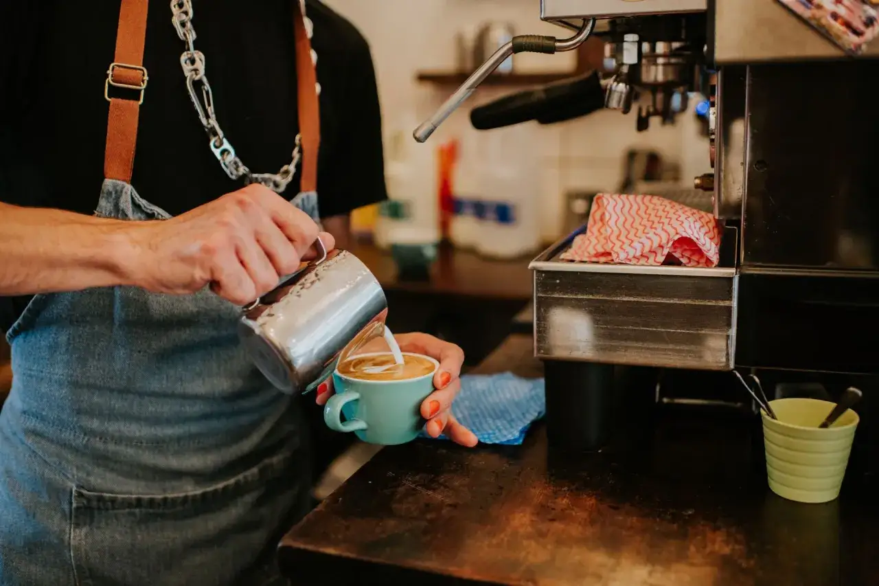 Barista tworzy latte art. Zastanawiasz się, ile kosztuje kurs na baristę, by tak tworzyć?