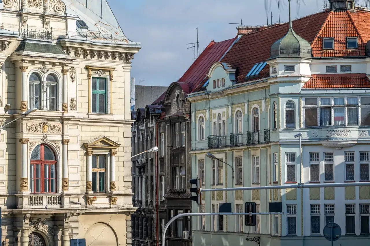 Kamienice na rynku w Bielsku-Białej, z bogatymi zdobieniami i różnorodnymi dachami, tworzą malowniczy widok.