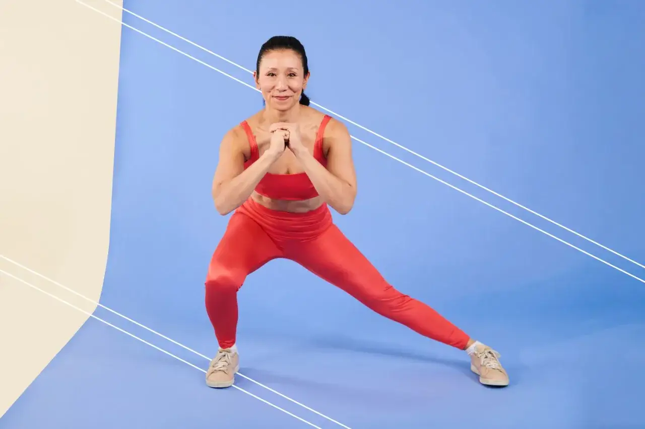 Frau in rotem Sport-Outfit macht Ausfallschritte, um ihre Oberschenkel zu trainieren.