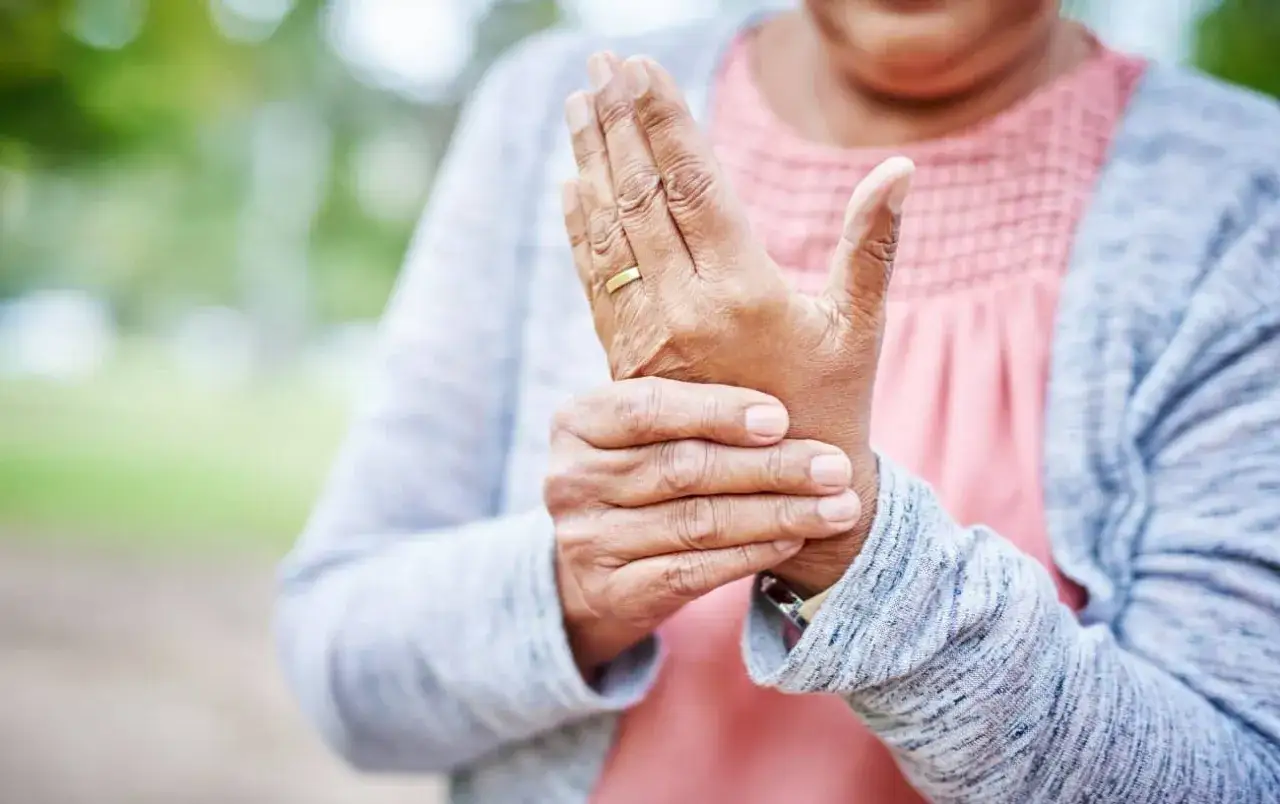 Mani gonfie dopo camminata, una donna si tiene il polso, forse per un leggero fastidio o per il caldo.