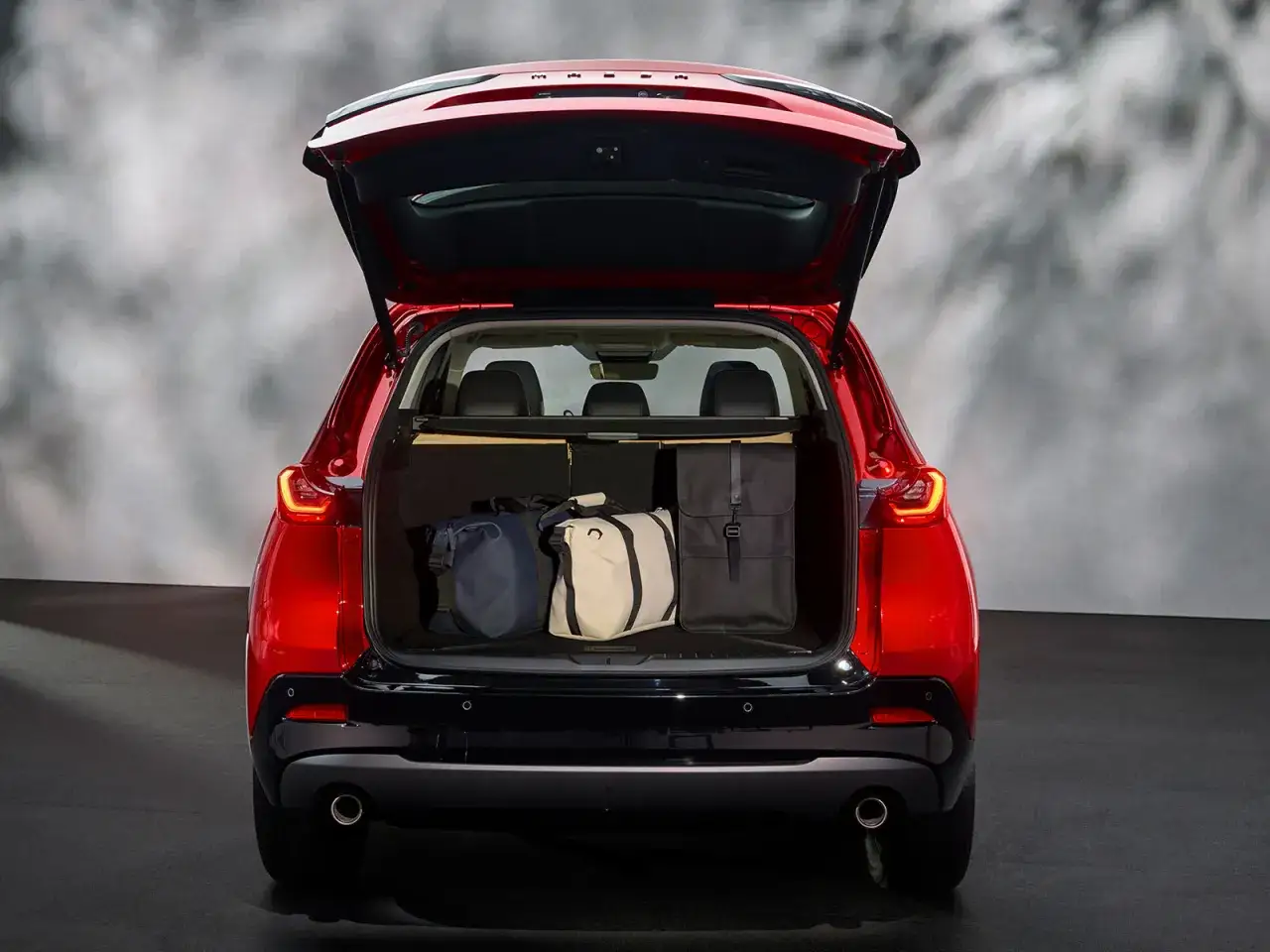 Maletero abierto del Mazda CX-5 rojo con tres bolsas de viaje. &iexcl;Listo para la aventura!