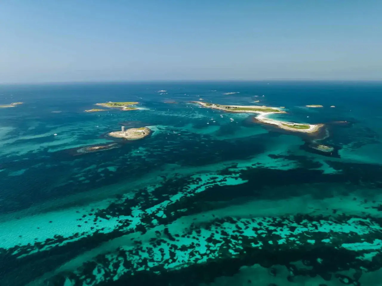 T&uuml;rkisblaues Wasser umgibt die Glenan Inseln mit einem Leuchtturm und vielen kleinen Inseln.