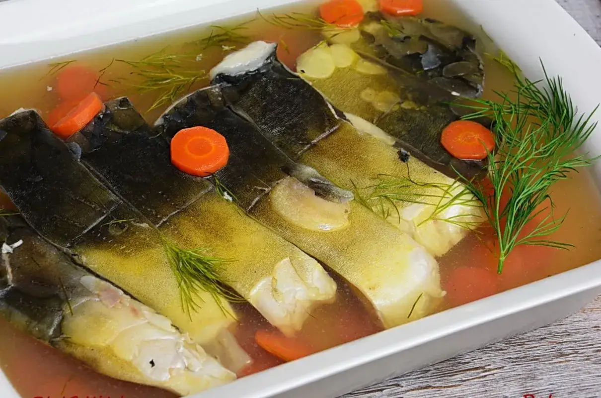 Karp po żydowsku w galarecie, z marchewką i koperkiem, gotowy do podania.