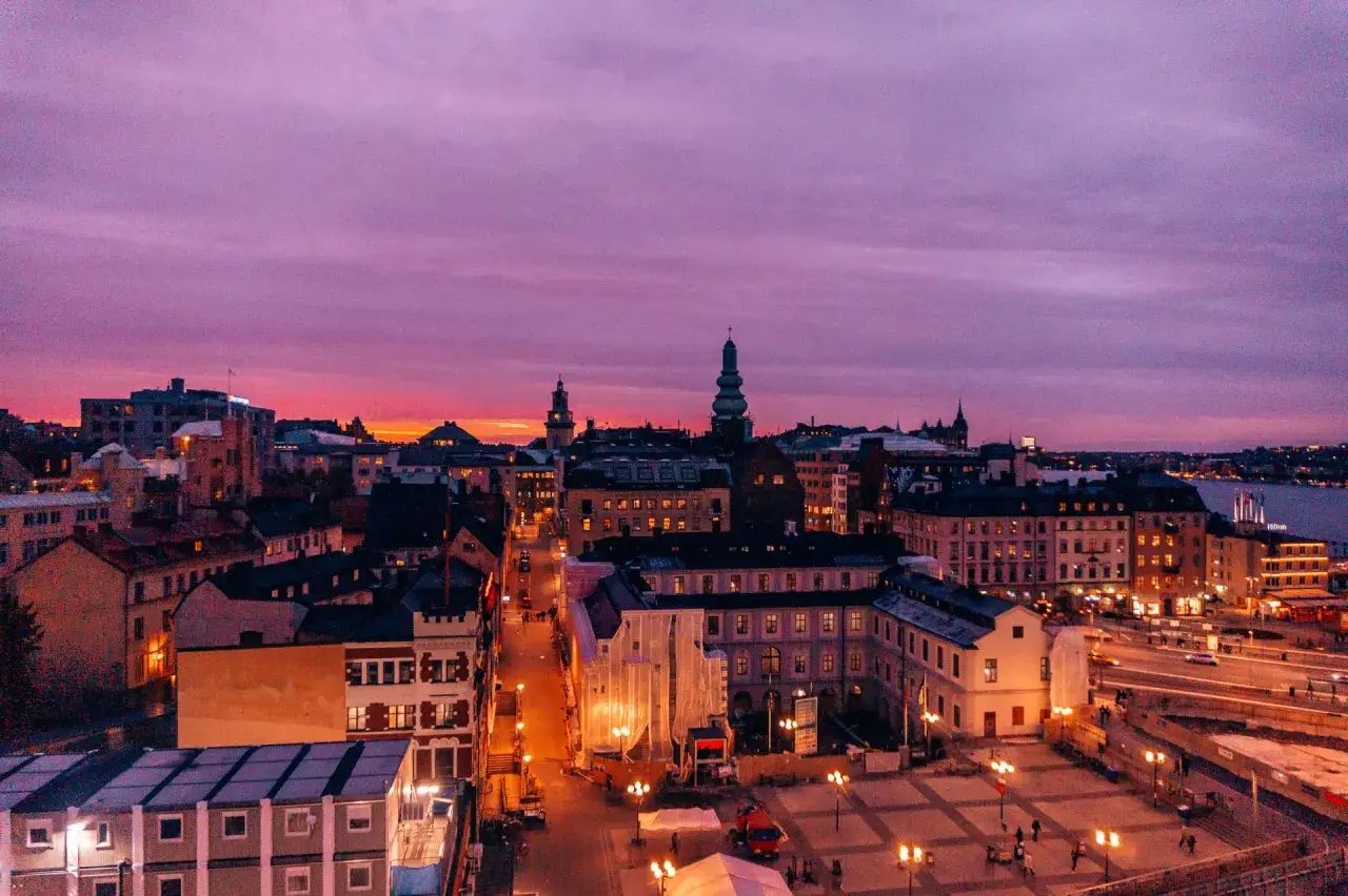 Zachód słońca nad Sztokholmem. Czy Szwecja to bezpieczny kraj? Miasto tętni życiem, a budynki rozświetlają uliczki.