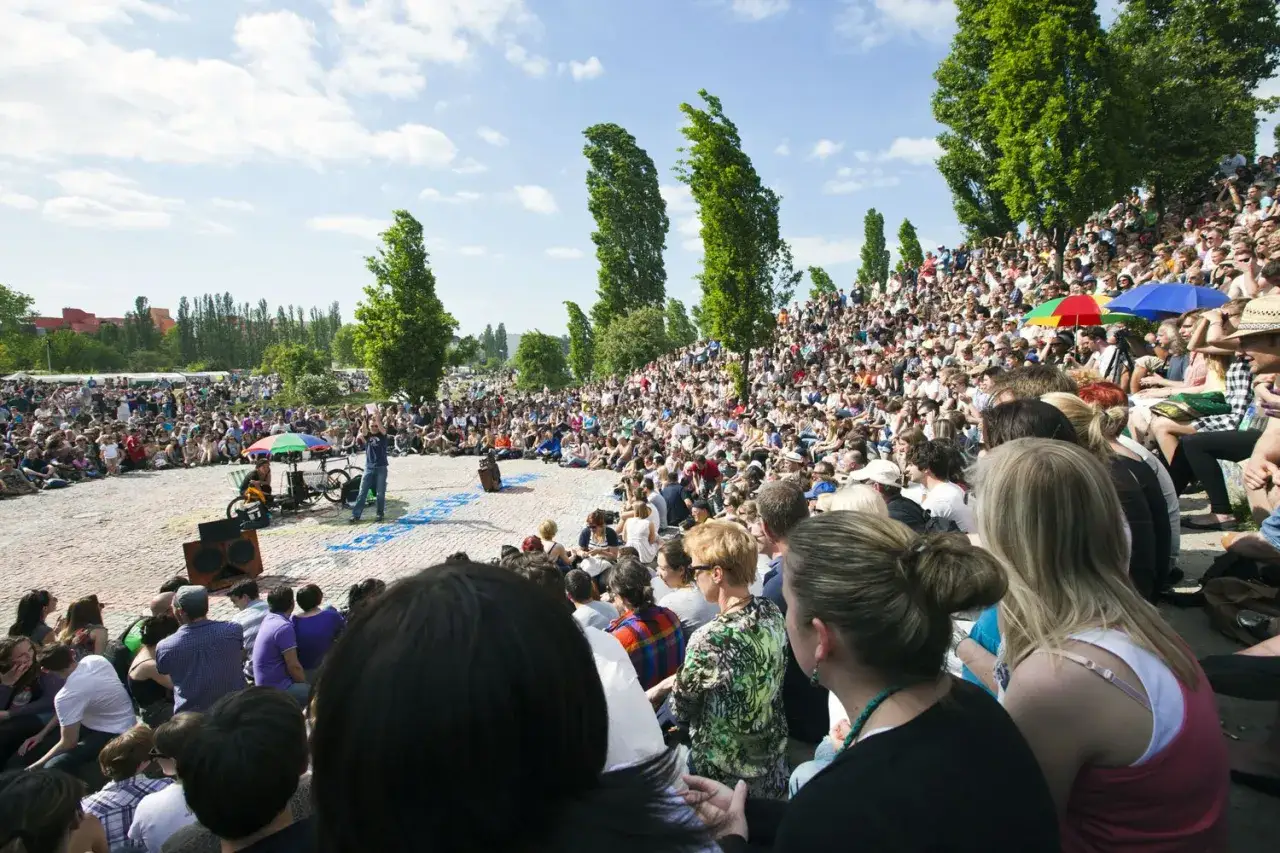 Gro&szlig;e Menschenmenge feiert Christi Himmelfahrt Berlin mit einer Open-Air-Veranstaltung. Ein Mann spricht zu den Zuschauern.