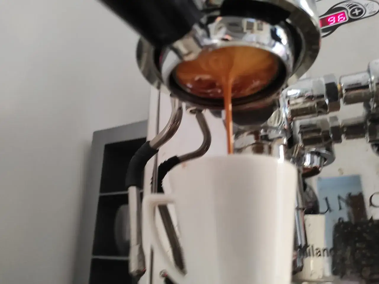 Espresso rinner ner i en vit kopp från en espressomaskin. En perfekt start på dagen med goda kaffesorter i Sverige.
