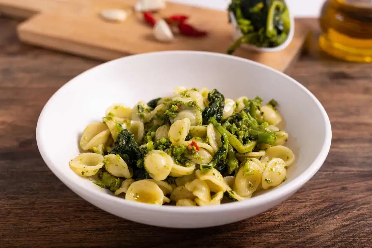 Orecchiette con cime di rapa, un classico delle orecchiette ricette pugliesi, condite con aglio, peperoncino e olio.