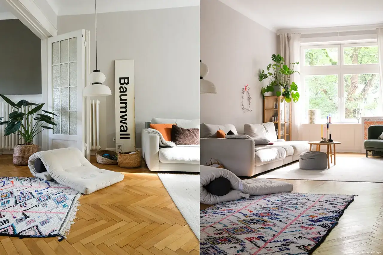 Gem&uuml;tliches Wohnzimmer in greige farbe mit wei&szlig;en Sofas, bunten Teppichen und viel Gr&uuml;n.