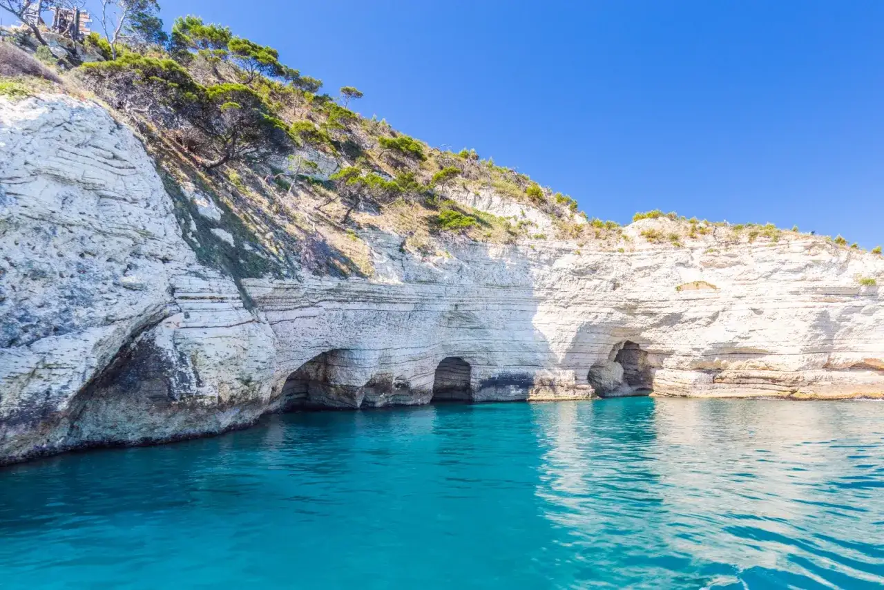 Scogliere bianche con grotte marine, l'acqua turchese sembra un pugno chiuso di bellezza naturale.