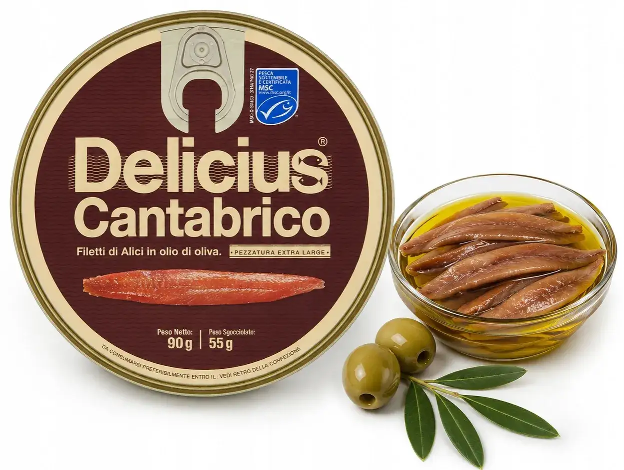 Puszka Delicius Cantabrico z filecikami ryby anchois w oliwie, obok miseczka z rybami i oliwki.